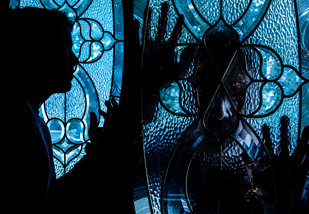 photograph of silhouette against glass, and man outside of glass door window.